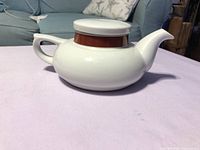Right side view showing teapot profile, handle, spout, lid, red stripe