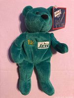 Front view of teal Jets #12 plush bear with tag