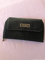Front of black Kate Spade cloth wallet with logo plaque