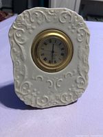 Front view of white Lenox porcelain desk clock with gold-tone bezel and Roman numeral dial