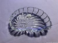 Top view of nautilus-shaped crystal dish showing spiral design and sticker