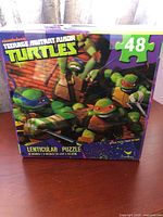 Front of puzzle box showing TMNT artwork, piece count, lenticular label
