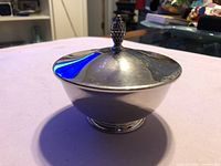 Profile view of silver-plate nut dish with lid