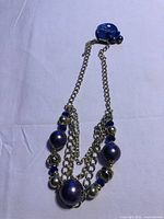 Full view of necklace showing multi-strand silver-tone chains and purple beads