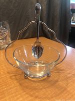 Front view of glass bowl in metal stand with spoon