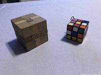 Wood cube puzzle and mini cube shown side by side