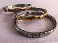 Three stretch bracelets displayed, showing rose, gold, silver tones