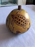 Full view of gourd showing carved turtle and wood knob