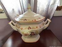Front view of ceramic soup tureen with lid and handles
