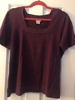Front view of purple Jaclyn Smith short-sleeve sweater on hanger