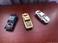 All three toy cars side by side on table