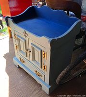 Front view of blue wooden wash stand showing doors, drawer, backsplash and hardware