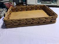 Top angled view of wicker casserole dish holder showing wicker weave and cork base