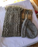 Two scarves and one beanie hat laid out on table