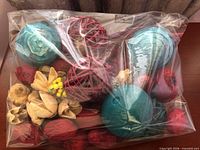Full view of sealed bag showing assorted rattan balls, wood flowers and pods