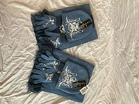 Two complete Twilight winter accessory sets laid out showing scarves, hats, gloves and attached tags