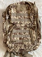 front view showing digital camo pattern, MOLLE webbing and brand patch