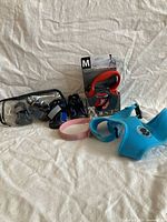 Group shot showing leash in package, boot set, harness, collar