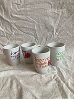 Four mugs front view showing designs