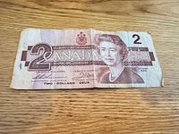 Obverse of 1986 Canadian $2 bill showing Queen Elizabeth II, denomination, serial, creases