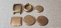 Six assorted gold-filled watch backs and case laid out