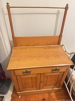 Front view of washstand showing towel bar, drawer, cabinet doors