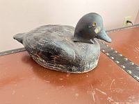 Left-front view of wooden duck decoy showing overall form and paint wear