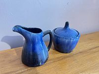 Creamer pitcher and lidded sugar bowl side by side