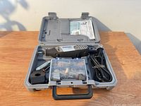 Entire kit open showing rotary tool, accessory box, guide and cord inside case