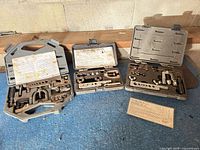 Three open flaring tool kits on blue floor