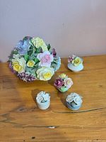 All five porcelain floral pieces on table