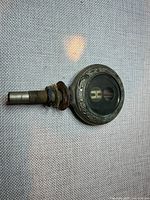 Front view of Boyce MotoMeter showing Hupmobile logo and floral bezel