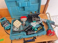 Makita case open showing drill, charger, attachments, bit set, screwdrivers, power block