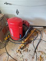 Full view of red MotoMaster air tank on yellow wheeled stand