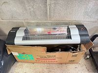 Heater resting partly in open carton
