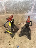 Pair of black and red jack stands on concrete floor