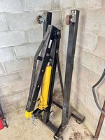 Crane folded against wall showing frame and hydraulic ram