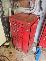 Front view of red steel tool cabinet showing drawers and side door