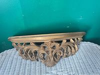 Front view showing ornate scroll design and gold finish