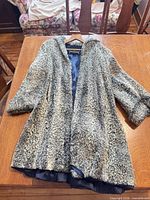 Full view of coat laid flat on table showing exterior and overall condition