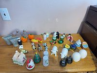 Overall lot of assorted salt & pepper shakers on wooden surface