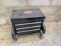 Front view of black STP rolling stool cabinet showing three drawers and casters.