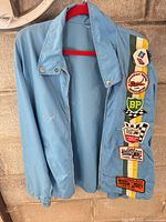 Front view of light blue racing patch jacket on hanger