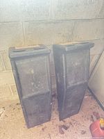 Two black plastic car ramps leaning against wall