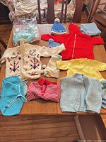 Group shot of all hand-knitted children’s garments spread on table