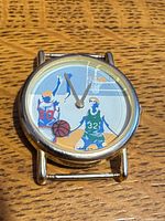 Front view showing basketball graphic dial and gold-tone case