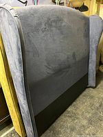 Full view of gray velvet wingback headboard showing overall design and color