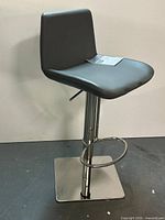 Full view of bar stool showing seat, back, chrome column, footrest, and square base