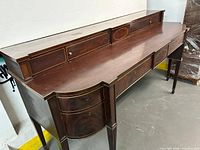 Full view of mahogany serpentine sideboard showing gallery and front drawers