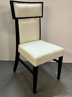 Full view of black lacquer chair with white vinyl seat and back